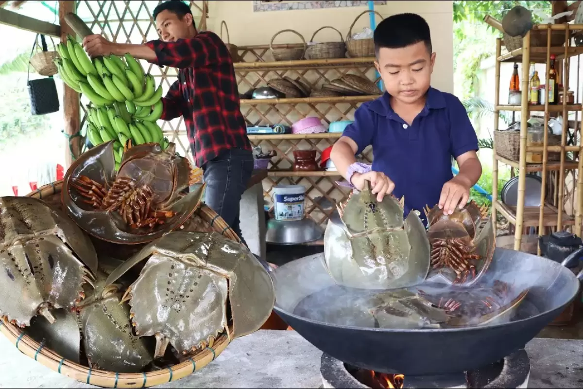 (ویدئو) ببینید این جوان روستایی تایلندی و برادر کوچک‌اش چگونه خرچنگ نعل اسبی طبخ می کنند