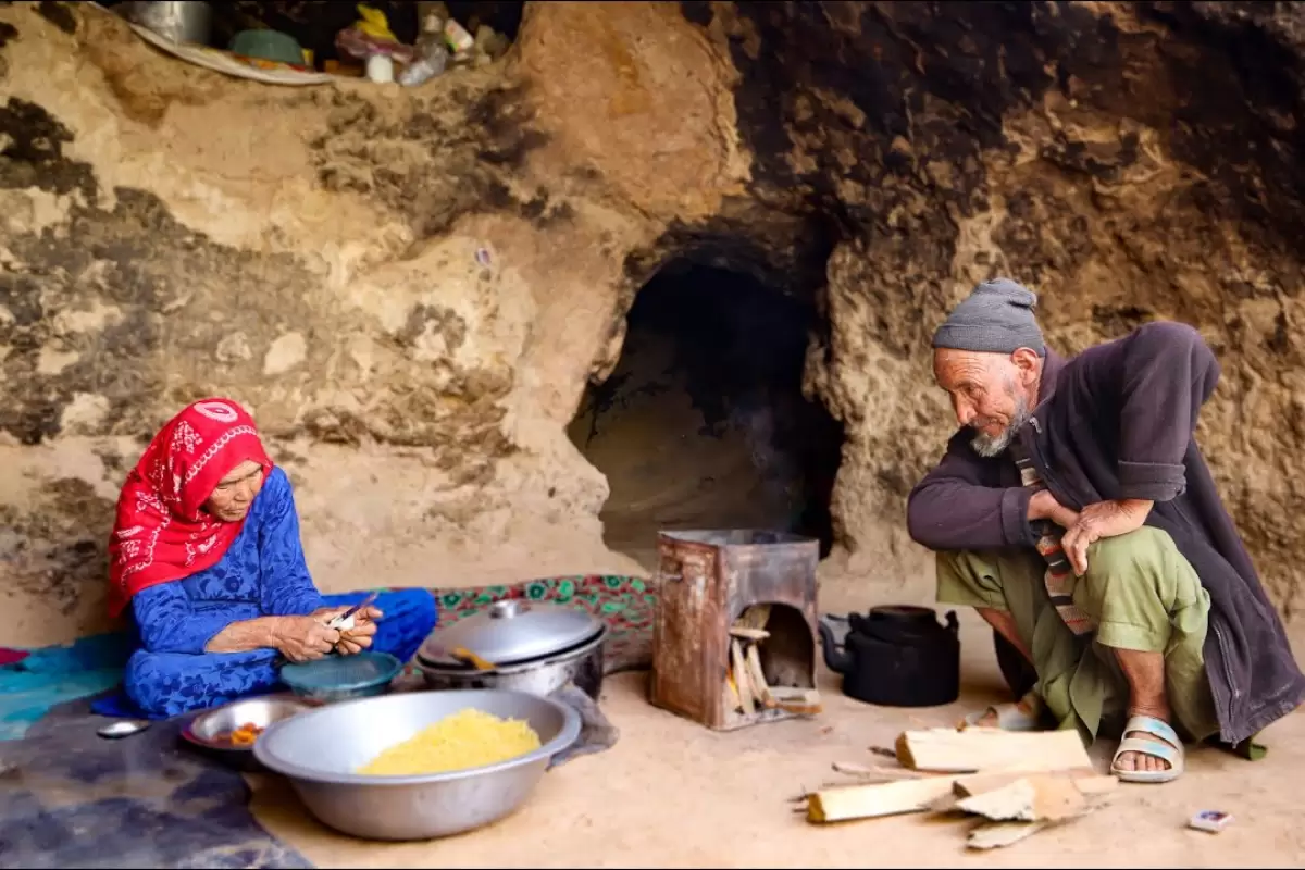 (ویدئو) زندگی عاشقانه زوج 80 ساله افغانستانی در غار؛ پخت متفاوت مرغ و سیب سرخ شده