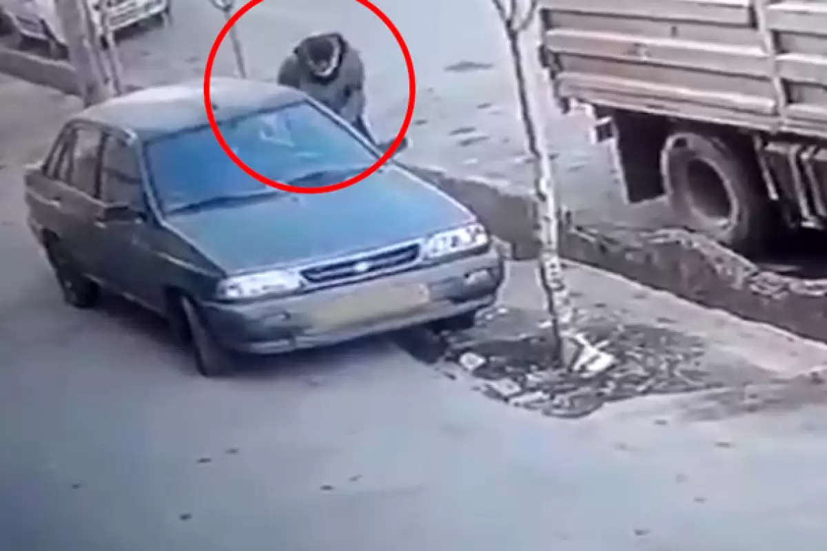 ببینید | لحظه هولناک حمله یک سارق با قمه به مالک ماشین مقابل خانه‌اش در حین سرقت!