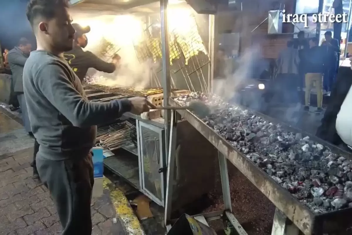 (ویدئو) غذای خیابانی؛ نحوه تهیه مرغ کبابی روی ذغال با نان عراقی در خیابان های کربلا