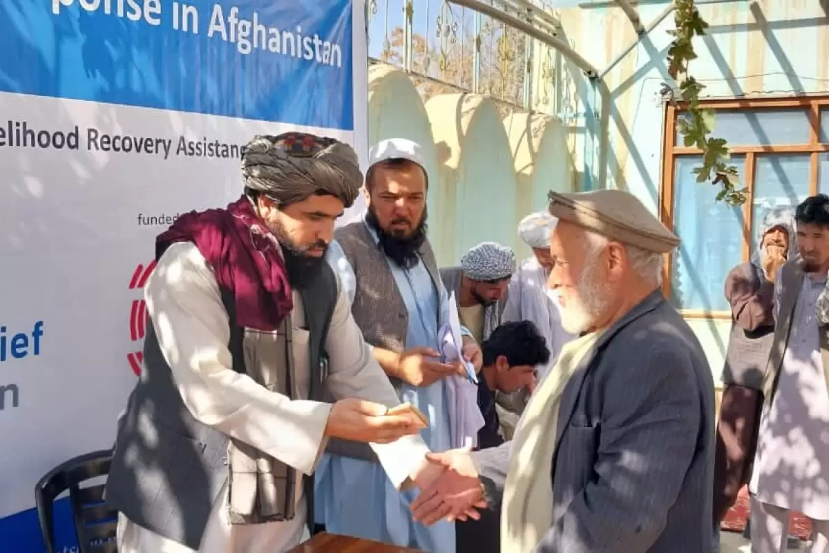 طالبان در حال پخش پول و غذا بین مهاجران افغان/عکس