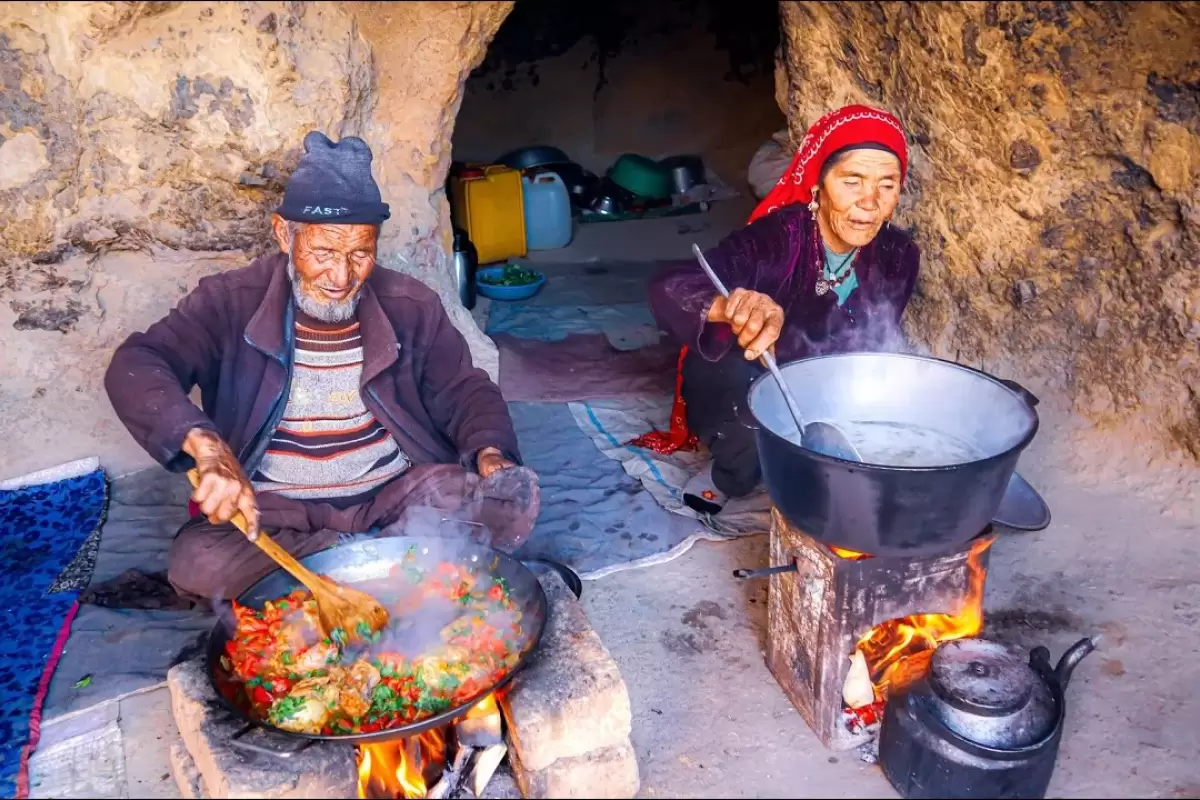 (ویدئو) پخت چلو مرغ به شیوه ای جدید توسط زوج مسن غارنشین افغانستانی