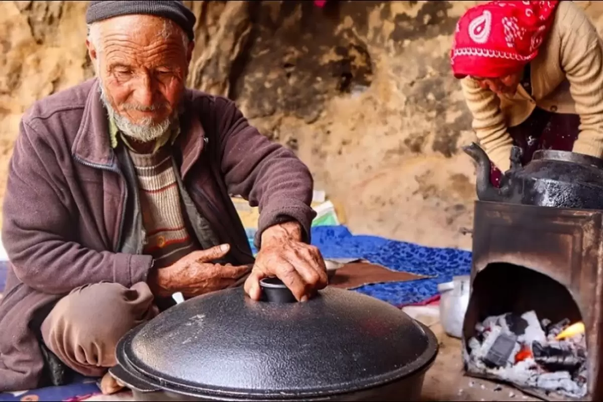 (ویدئو) پخت نان روی ساج و قابلی پلو با مرغ توسط زوج مسن غارنشین افغانستانی