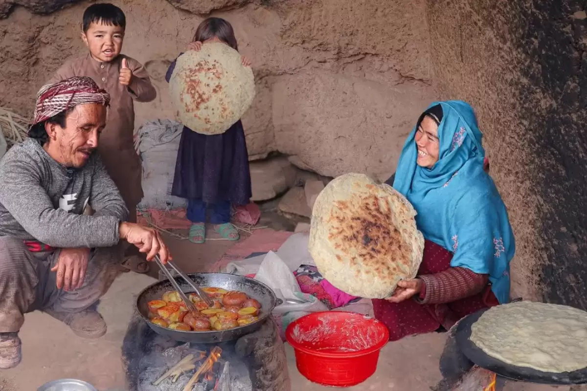 (ویدئو) فرآیند پخت یک غذای محلی با سیب زمینی توسط زوج جوان افغان در غار