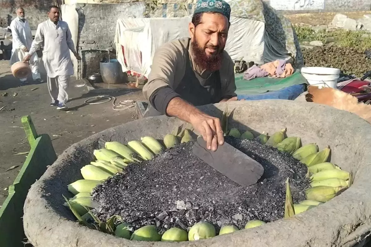 (ویدئو) غذای خیابانی در پاکستان؛ پخت بلال در ماسه داغ در پنجاب