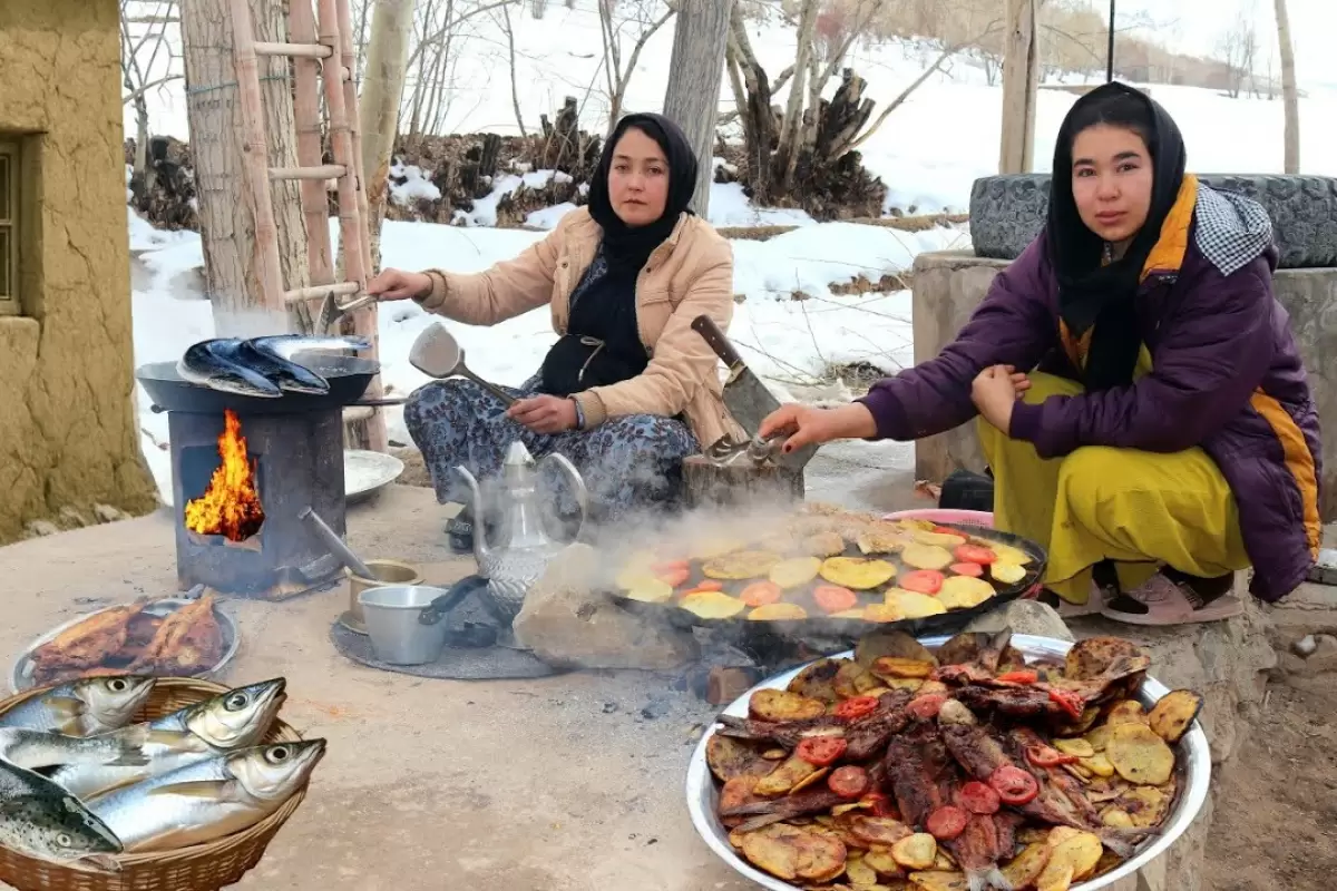 ببینید؛ غذای روستایی در افغانستان؛ پخت ماهی با سیب زمینی و گوجه در هوای برفی